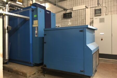 Große blaue Buderus Heizungsanlage mit Heizkessel und technischer Steuerung in einem gewerblichen Heizraum.
