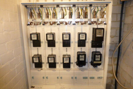Modernisierte Elektroverteilung mit mehreren Stromzählern, neu geordneter Verkabelung und Sicherungselementen.