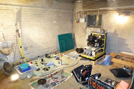 Heizungsanlage während umfangreicher Wartungs- und Reparaturarbeiten mit Werkzeugen und ausgebauten Bauteilen im Keller.