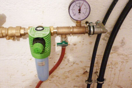 Trinkwasserinstallation mit Grünbeck Wasserfilter, Druckminderer, Manometer und angeschlossenen Rohrleitungen.
