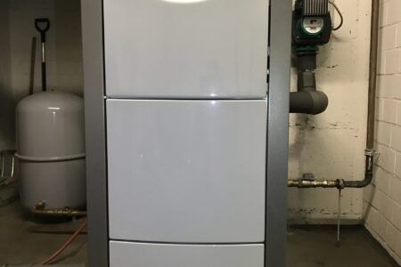 Vaillant Heizkessel mit Rohrleitungen, Umwälzpumpe und Ausdehnungsgefäß in einem Heizungsraum.