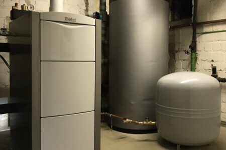 Heizungsraum mit Vaillant Heizkessel, großem Warmwasserspeicher, Ausdehnungsgefäß und gedämmten Rohrleitungen.