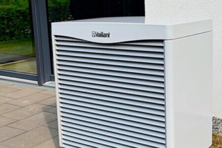 Weiße Vaillant Wärmepumpe als Außengerät vor einem Gebäude
